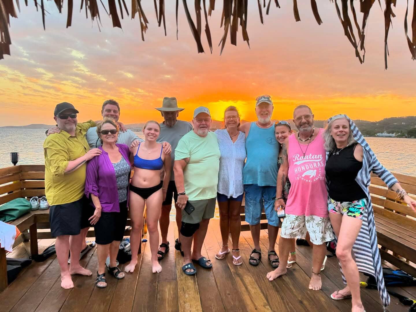 Relaxing sunset Tiki Boat adventure in Roatan, featuring a group of friends on a tropical cruise during sunset, with stunning ocean views.